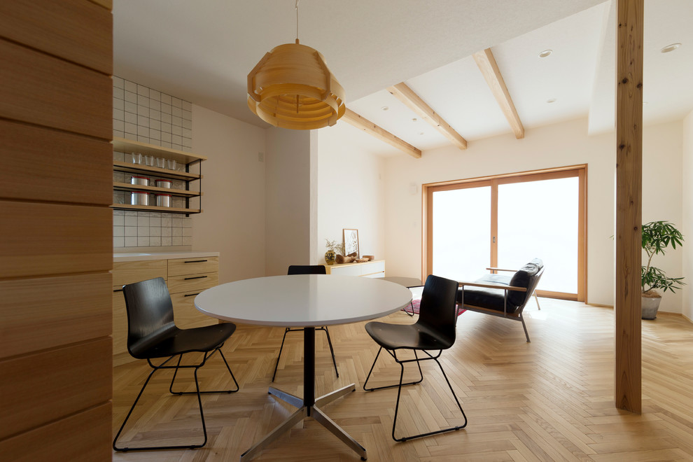 Ispirazione per una sala da pranzo aperta verso il soggiorno nordica con pareti bianche, parquet chiaro e pavimento marrone