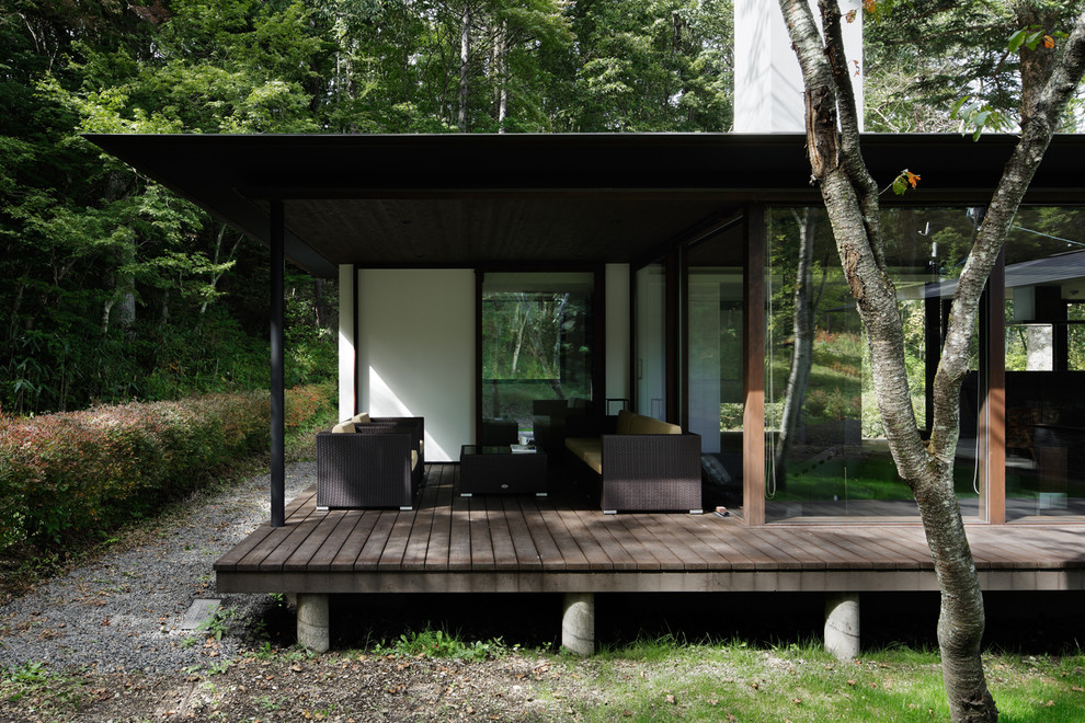 Idee per un patio o portico moderno davanti casa con pedane e un tetto a sbalzo
