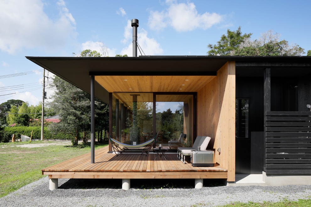 Aménagement d'une terrasse en bois avant asiatique avec une extension de toiture.