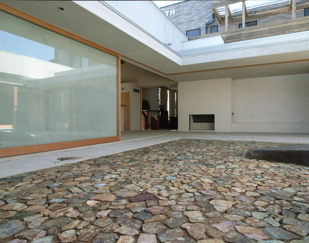 Esempio di un patio o portico moderno di medie dimensioni e in cortile con pavimentazioni in pietra naturale e un tetto a sbalzo