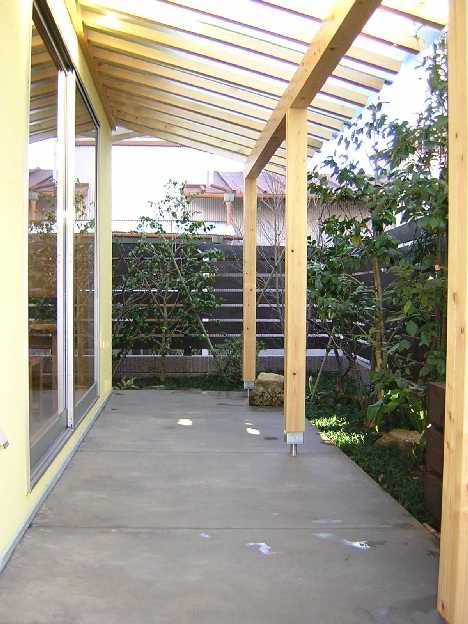 Modelo de patio asiático pequeño en patio delantero con adoquines de hormigón y pérgola