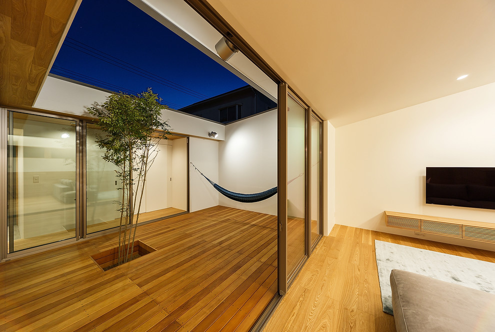 Immagine di un patio o portico minimalista di medie dimensioni e in cortile con pedane e un tetto a sbalzo