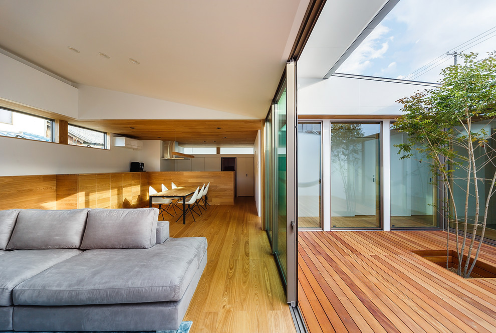 Idées déco pour une terrasse en bois moderne de taille moyenne avec une cour et une extension de toiture.