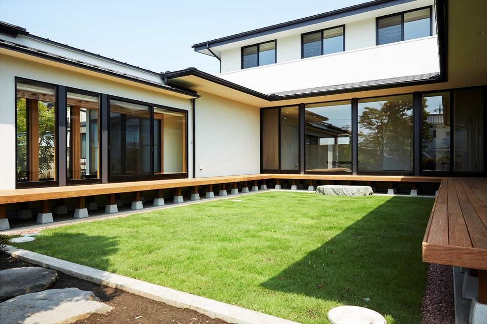 Ejemplo de patio de estilo zen grande en patio y anexo de casas con entablado