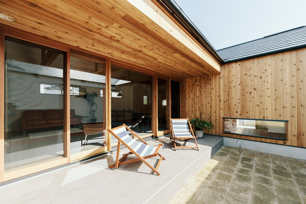 Modelo de patio de estilo zen en patio y anexo de casas con suelo de baldosas