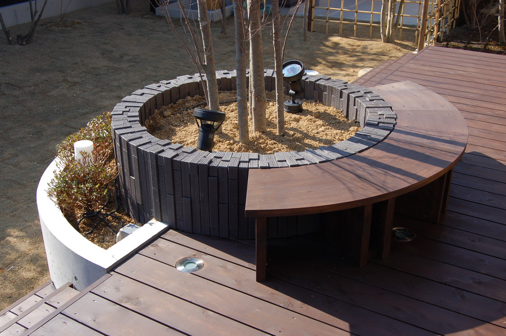 Cette image montre une terrasse en bois avant asiatique avec une extension de toiture.
