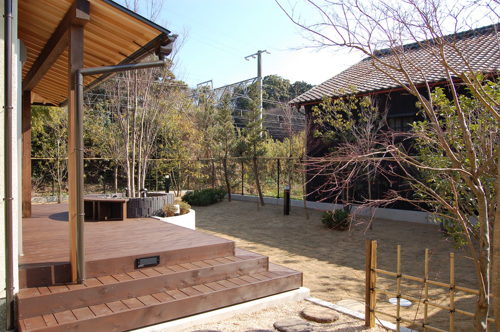 Esempio di un patio o portico etnico davanti casa con pedane e un tetto a sbalzo