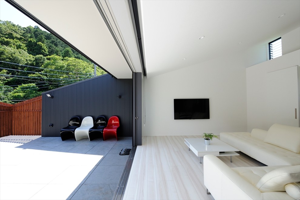 Immagine di un ampio patio o portico minimalista davanti casa con piastrelle