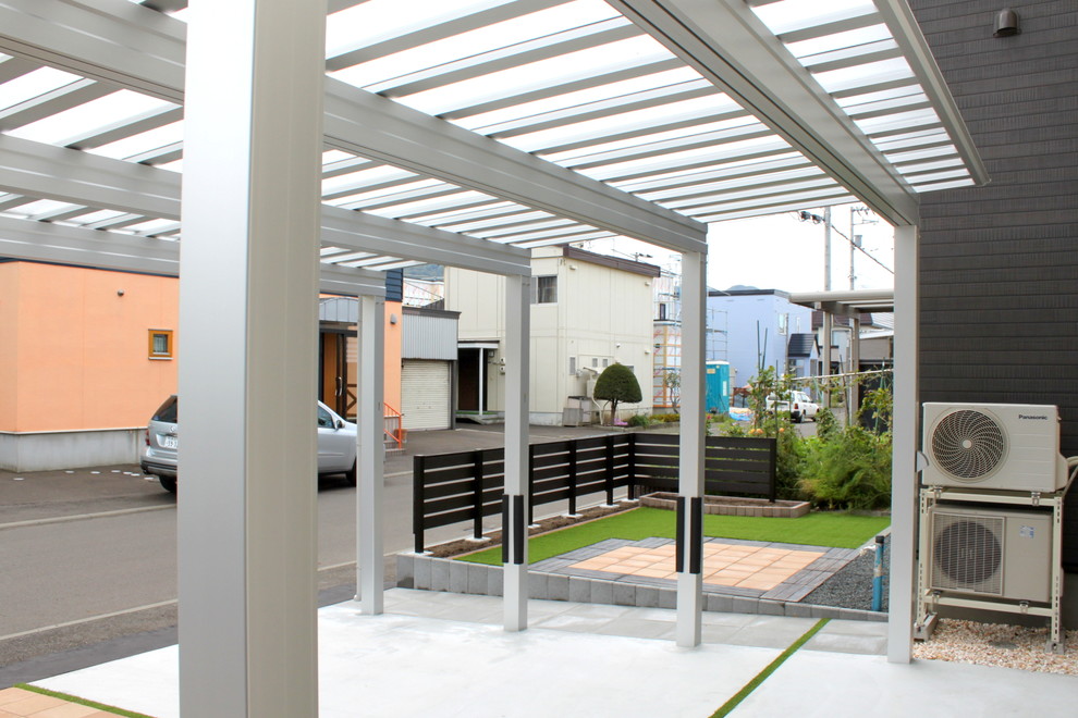 Ispirazione per un patio o portico minimalista davanti casa con lastre di cemento e nessuna copertura