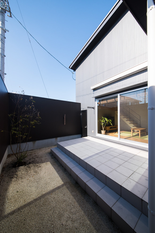 Идея дизайна: двор на переднем дворе в восточном стиле с покрытием из плитки