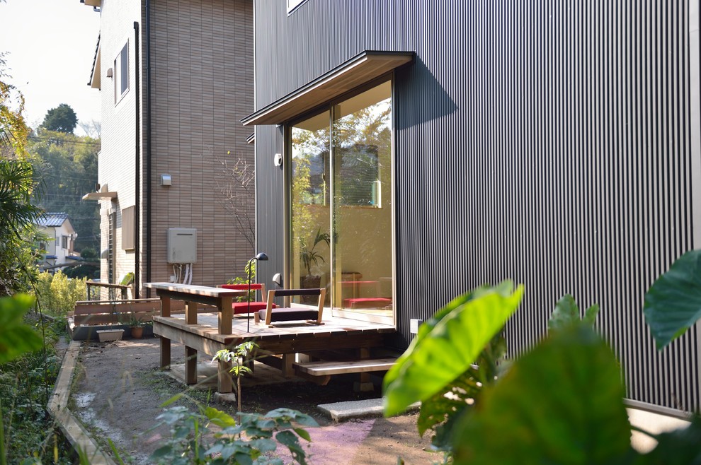 Inspiration pour une terrasse en bois asiatique avec une extension de toiture.