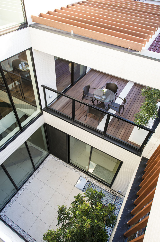 Идея дизайна: двор среднего размера на внутреннем дворе в стиле модернизм с покрытием из плитки без защиты от солнца