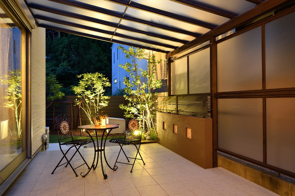 This is an example of a world-inspired courtyard patio in Fukuoka with an awning.