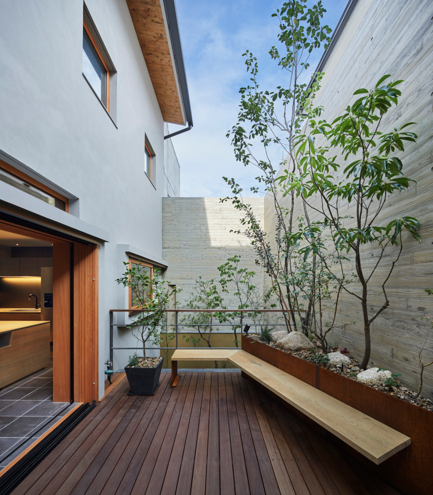 Diseño de patio actual de tamaño medio sin cubierta en patio trasero con entablado