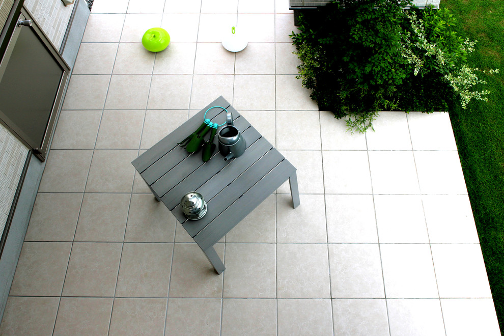 Design ideas for a contemporary courtyard patio in Yokohama with tiled flooring and no cover.