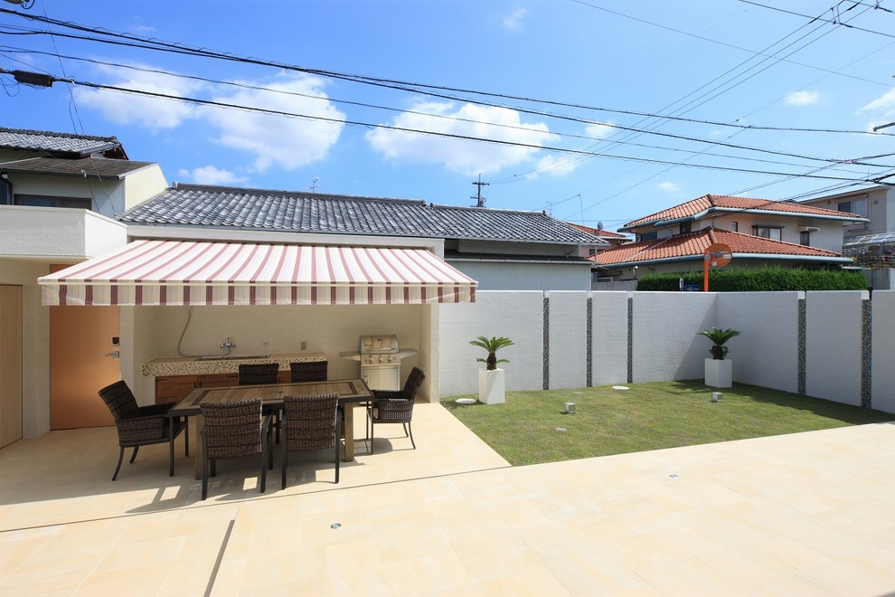 Esempio di un patio o portico moderno dietro casa con un parasole