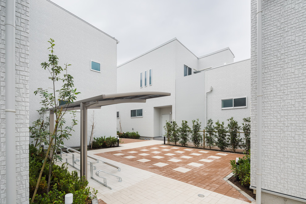 Ispirazione per un patio o portico minimalista di medie dimensioni e in cortile con pavimentazioni in mattoni