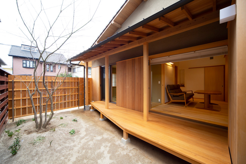 Idée de décoration pour une terrasse en bois arrière asiatique avec une extension de toiture.
