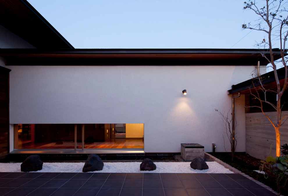 Ispirazione per un grande patio o portico moderno in cortile con piastrelle e un tetto a sbalzo