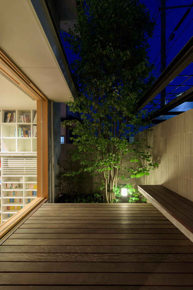 Cette image montre une terrasse en bois minimaliste avec une cour.