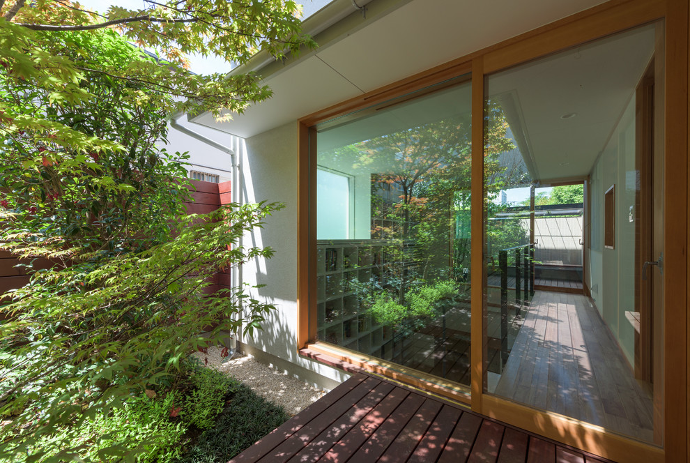 Exemple d'une terrasse en bois moderne avec une cour.