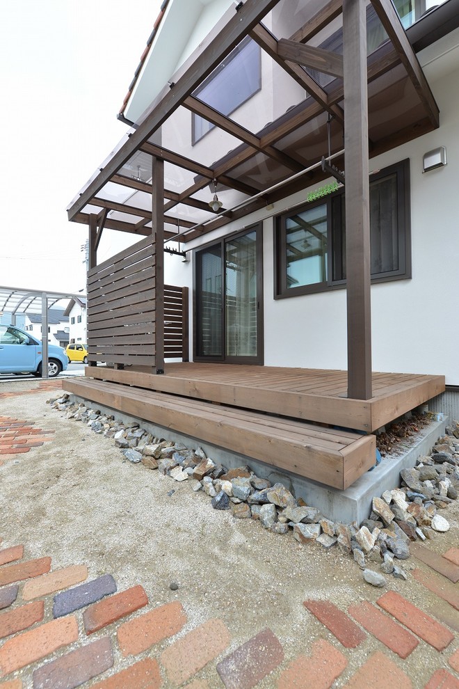 Esempio di un patio o portico scandinavo di medie dimensioni con pavimentazioni in mattoni e un parasole