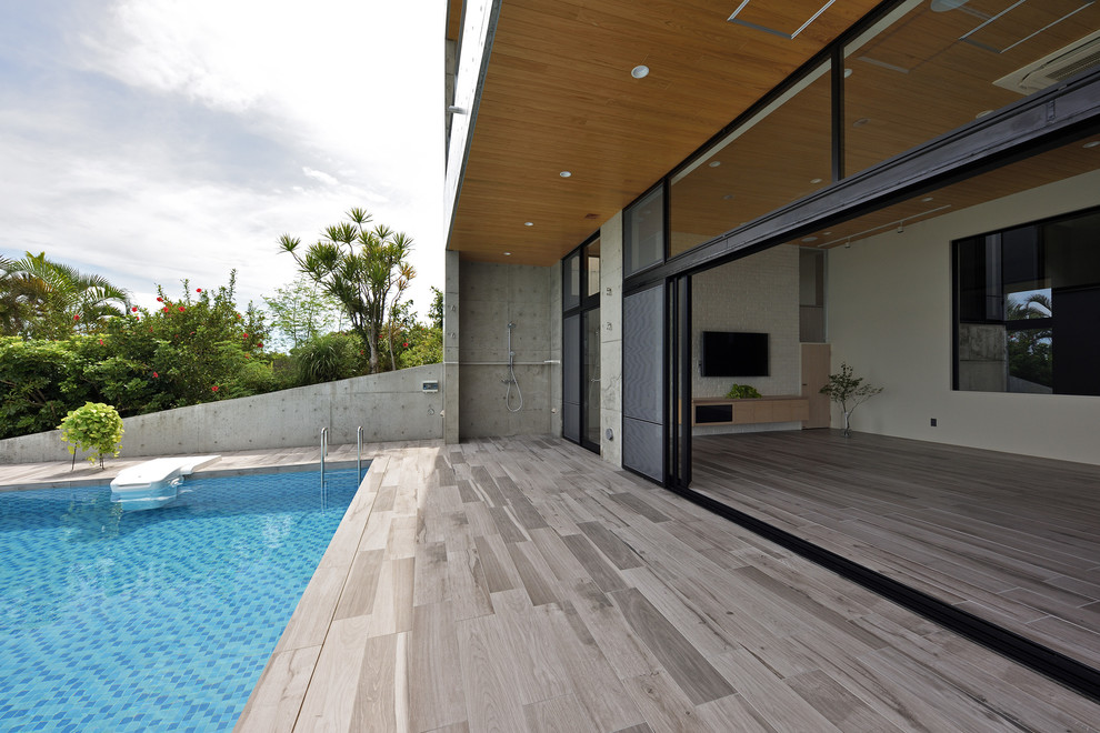 Immagine di un patio o portico design dietro casa con pedane e un tetto a sbalzo