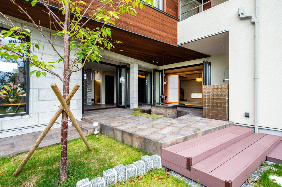Modelo de patio asiático de tamaño medio en patio delantero y anexo de casas con brasero y suelo de baldosas