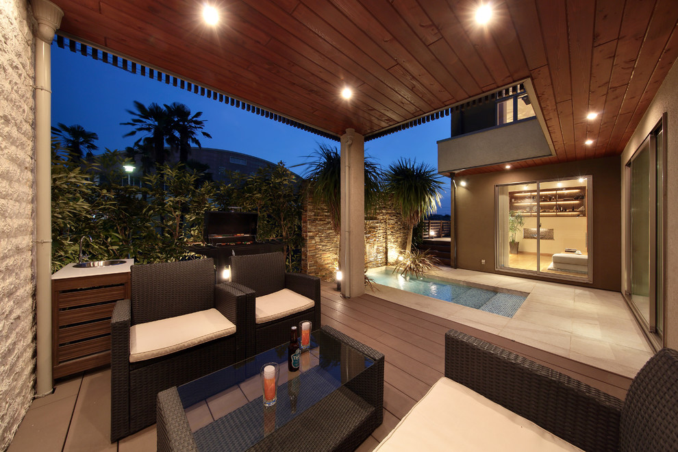 World-inspired courtyard patio in Other with decking and a roof extension.