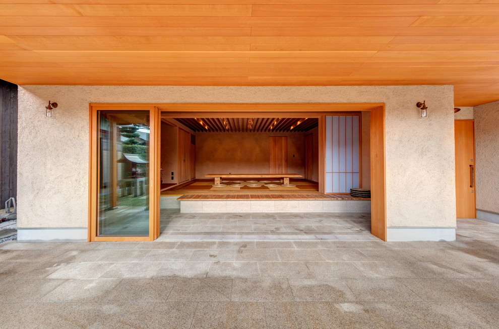 Modelo de patio de estilo zen en patio delantero y anexo de casas con suelo de baldosas