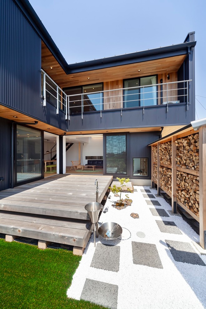 Aménagement d'une terrasse en bois arrière industrielle de taille moyenne avec une extension de toiture.