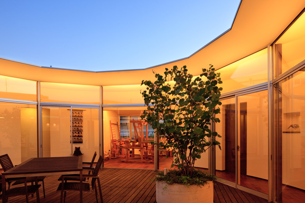 Ispirazione per un patio o portico minimalista di medie dimensioni e in cortile con pedane e un tetto a sbalzo
