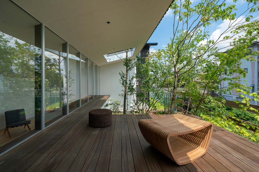 Réalisation d'une terrasse arrière minimaliste de taille moyenne avec une extension de toiture.