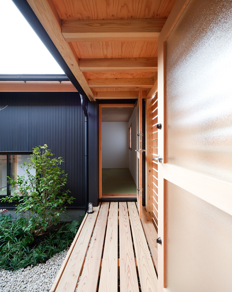 Modelo de patio de estilo zen pequeño en patio y anexo de casas con adoquines de piedra natural