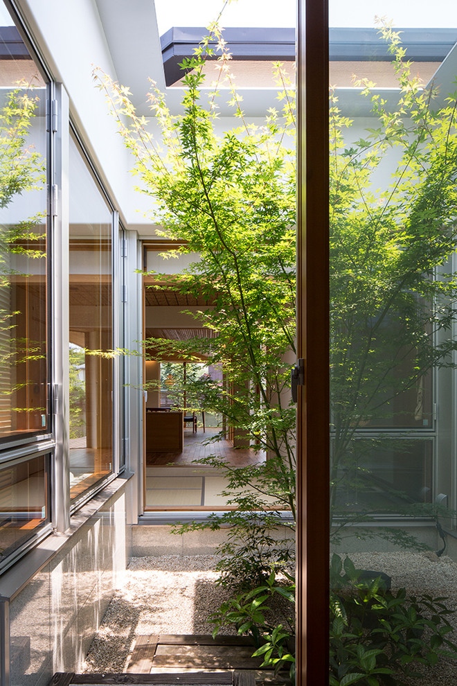Свежая идея для дизайна: двор среднего размера на внутреннем дворе в восточном стиле с покрытием из гравия и навесом - отличное фото интерьера
