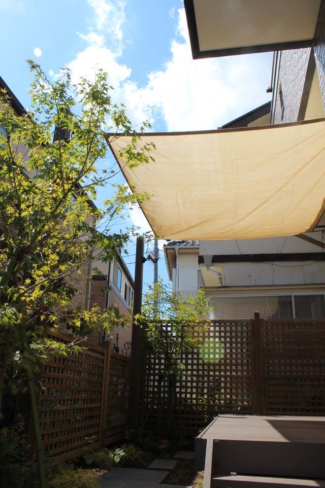 Idee per un patio o portico etnico dietro casa con un parasole