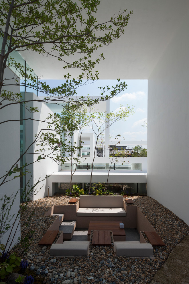Idee per un patio o portico minimal in cortile con pavimentazioni in pietra naturale e un tetto a sbalzo