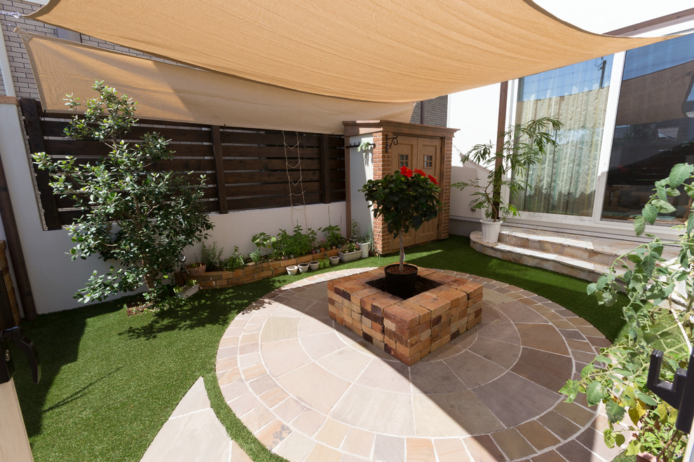 This is an example of a world-inspired patio in Other with an awning.