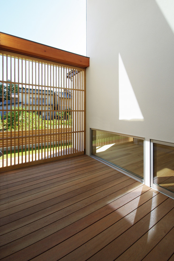 Idées déco pour une terrasse en bois asiatique avec une cour et une extension de toiture.