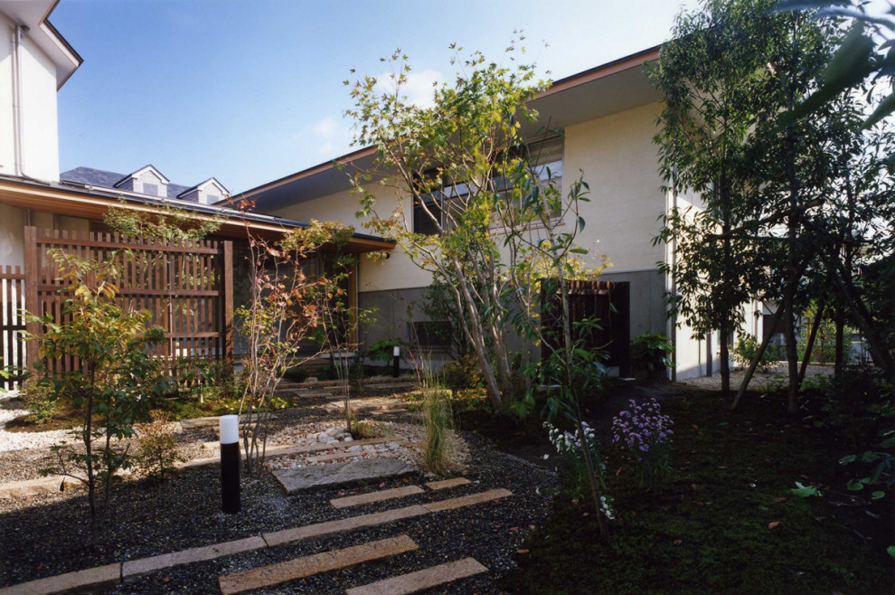 Cette photo montre une terrasse arrière asiatique de taille moyenne avec du gravier et une extension de toiture.