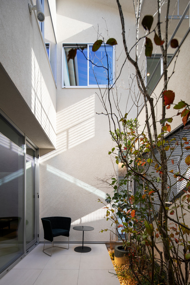 Foto de patio moderno pequeño en patio y anexo de casas con suelo de baldosas