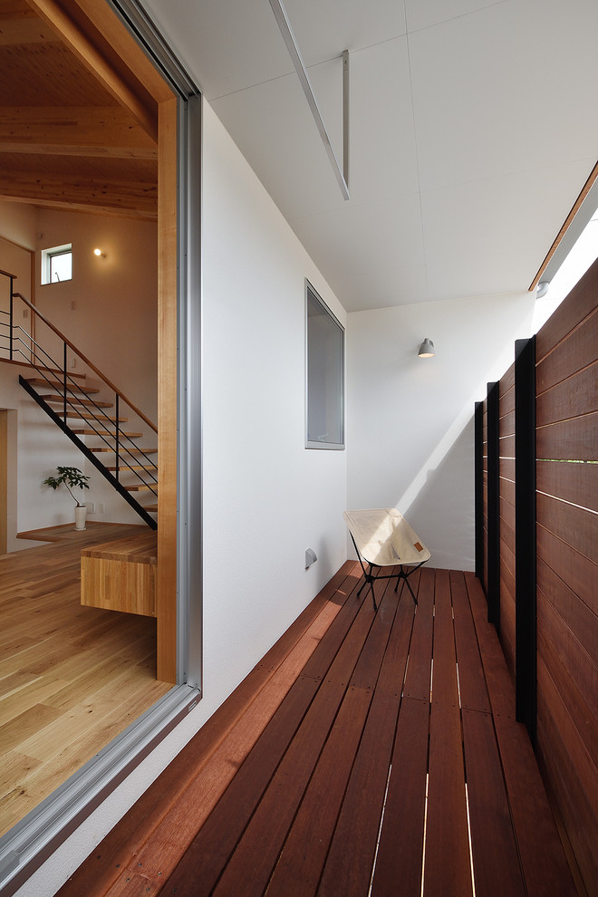This is an example of a small scandinavian private wood railing balcony in Other with a roof extension.