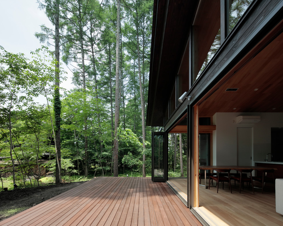 Immagine di un patio o portico minimalista con pedane e un tetto a sbalzo