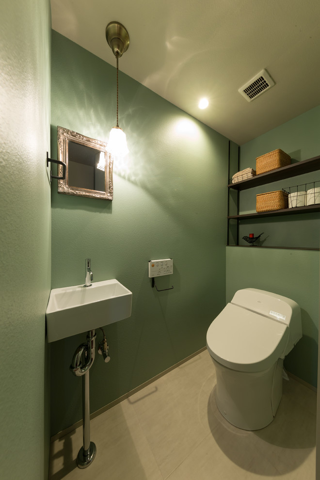 Idées déco pour un WC et toilettes classique avec un mur vert et un sol beige.