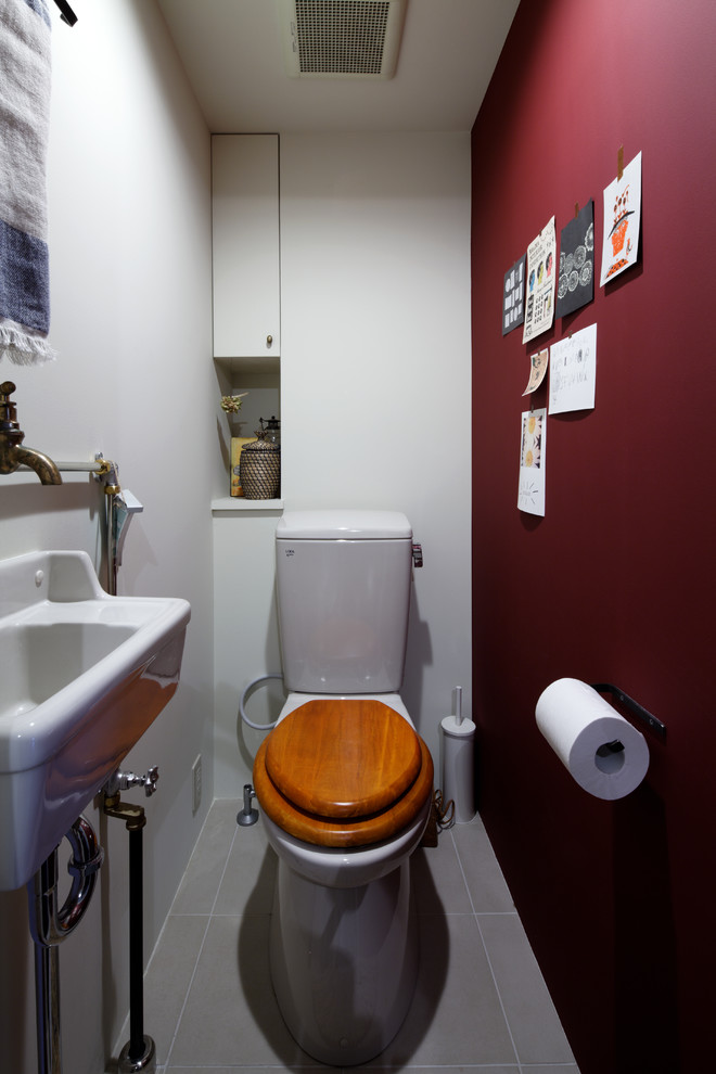 Immagine di un bagno di servizio minimal con pareti multicolore, lavabo sospeso e pavimento grigio