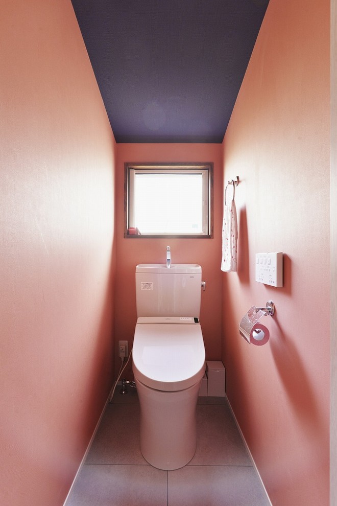 Immagine di un bagno di servizio contemporaneo con pareti rosa e pavimento grigio