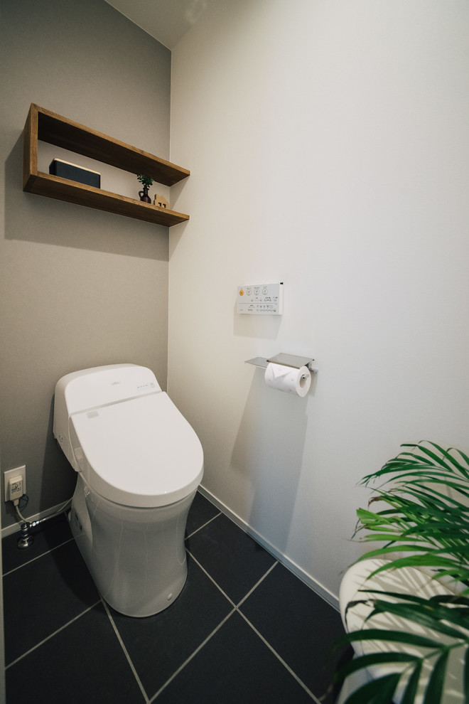 Foto på ett funkis toalett, med grå väggar, klinkergolv i porslin och svart golv