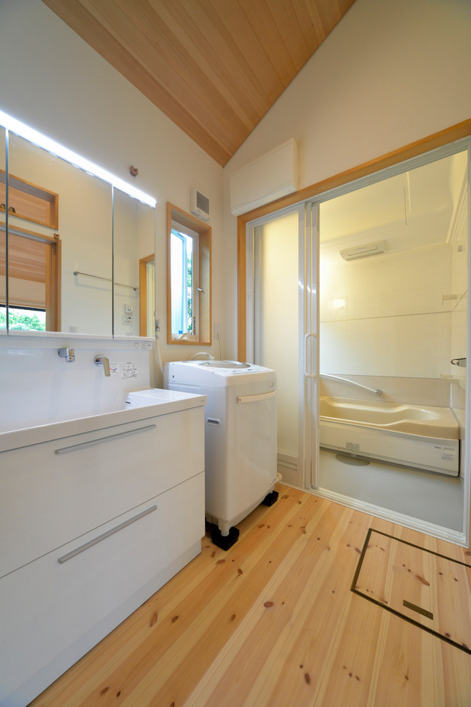 Réalisation d'un WC et toilettes chalet avec des portes de placard blanches, un mur blanc et un lavabo intégré.