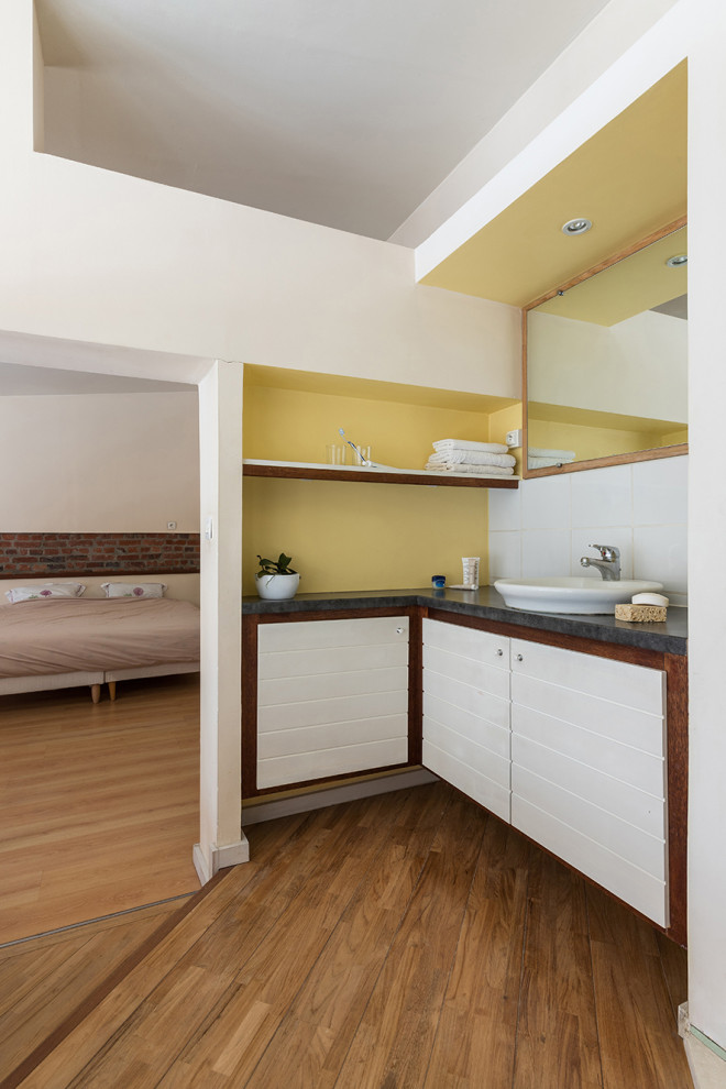 Réalisation d'un WC et toilettes minimaliste en bois foncé avec un mur jaune, une vasque et meuble-lavabo encastré.