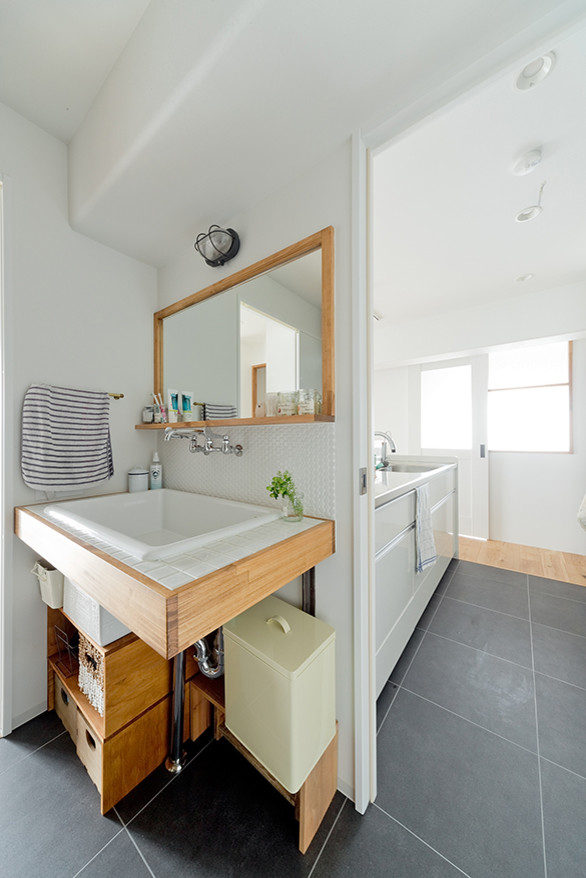 Immagine di un bagno di servizio nordico con piastrelle bianche, piastrelle in gres porcellanato, pareti bianche, pavimento in legno massello medio, top piastrellato e pavimento beige